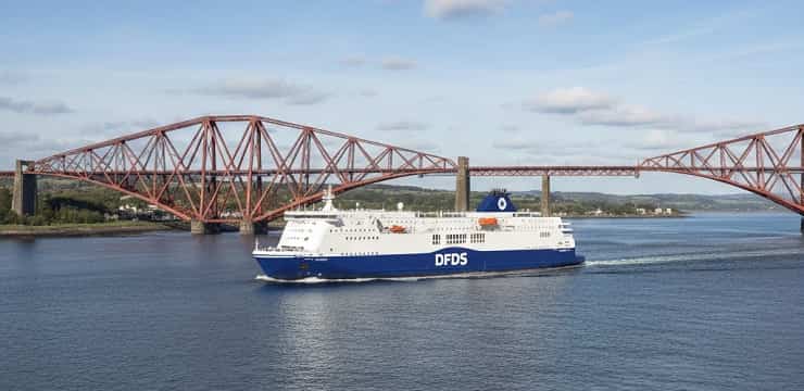 Niebieski prom pasażerski DFDS płynący obok mostu Forth bridge w Szkocji - informacja edynburg.online